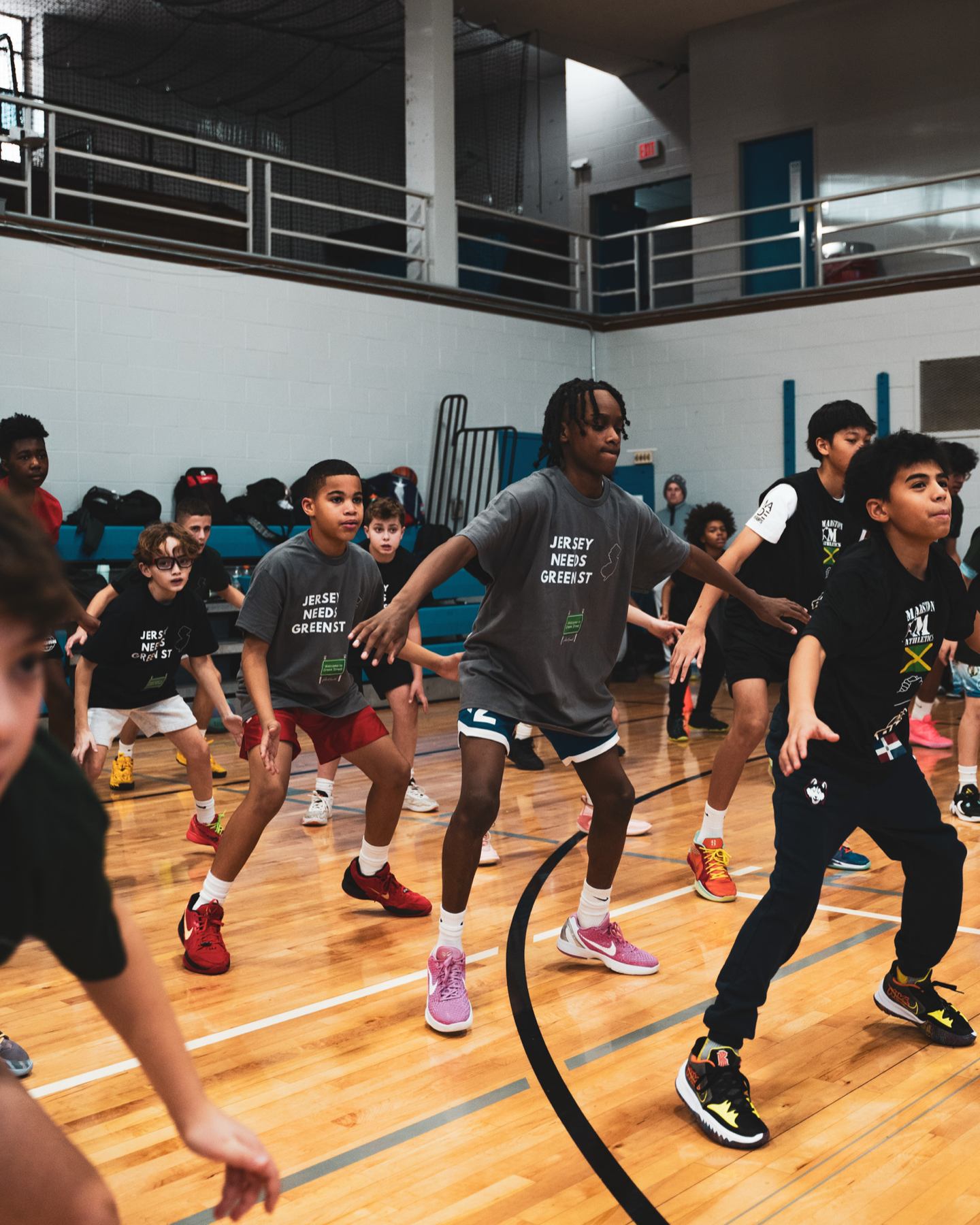 Players of all ages in a defensive slide drill at a Marston Athletics clinic
