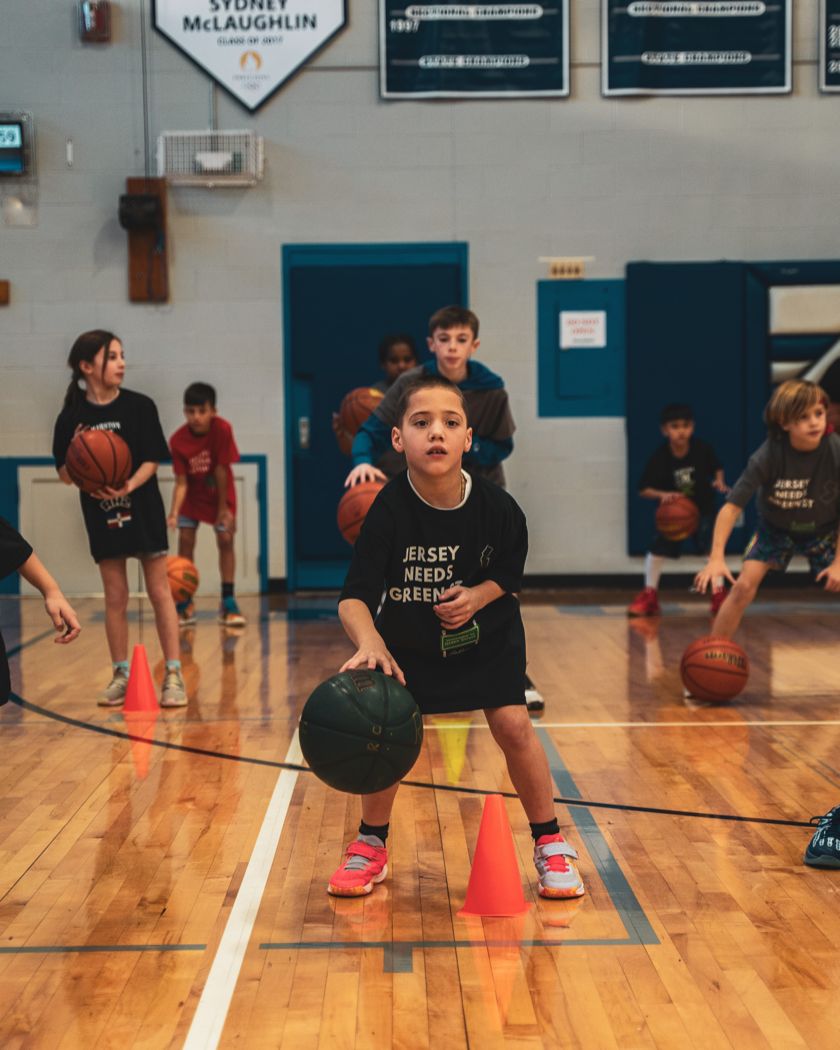 A young player dribbling between cones at a Marston Athletics clinic